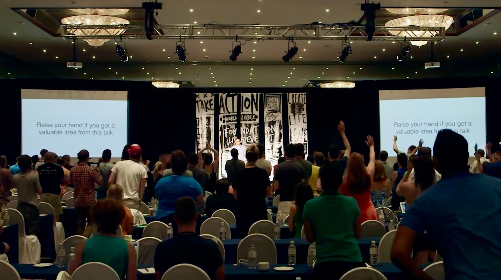 Rob Scott engaging with an audience, hands raised in participation during a live event about growth and transformation